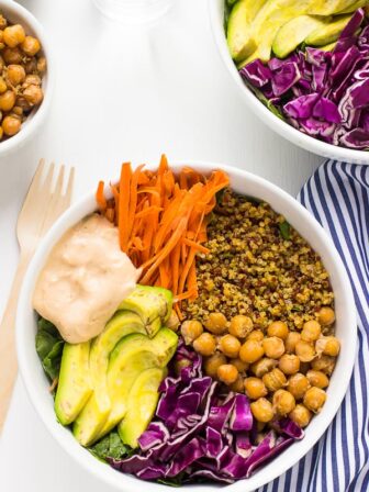 Two nourish buddha bowls on a white table.