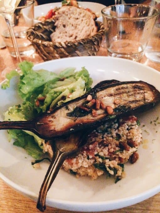 Grilled eggplant on a white plate in a restaurant.