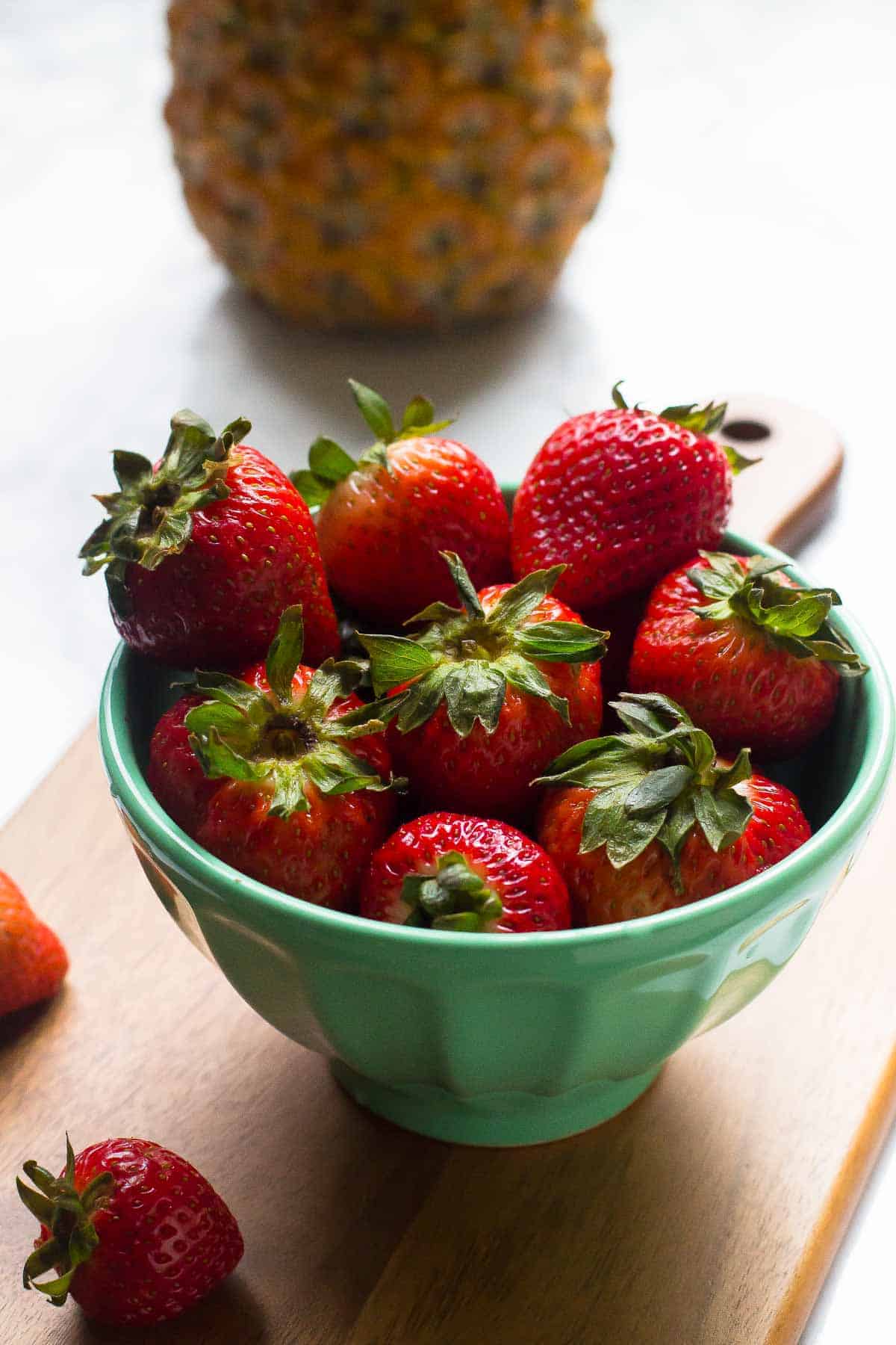 A blue bowl full of strawberries.