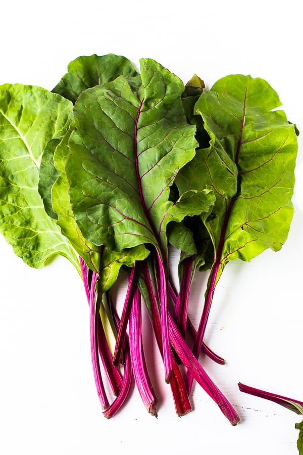 Top down shot of raw swiss chard on a white background. 