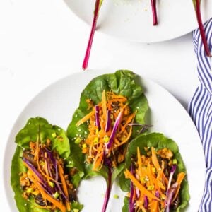 Overhead shot of swiss chard wraps on white plates.