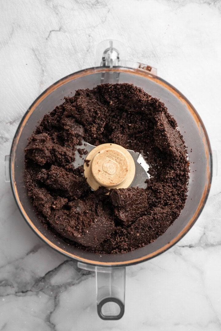 Mixture for no bake brownie energy bites in food processor.