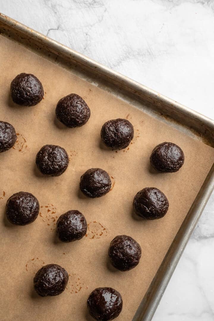 Vegan no bake brownie energy bites on pan before coating in coconut.