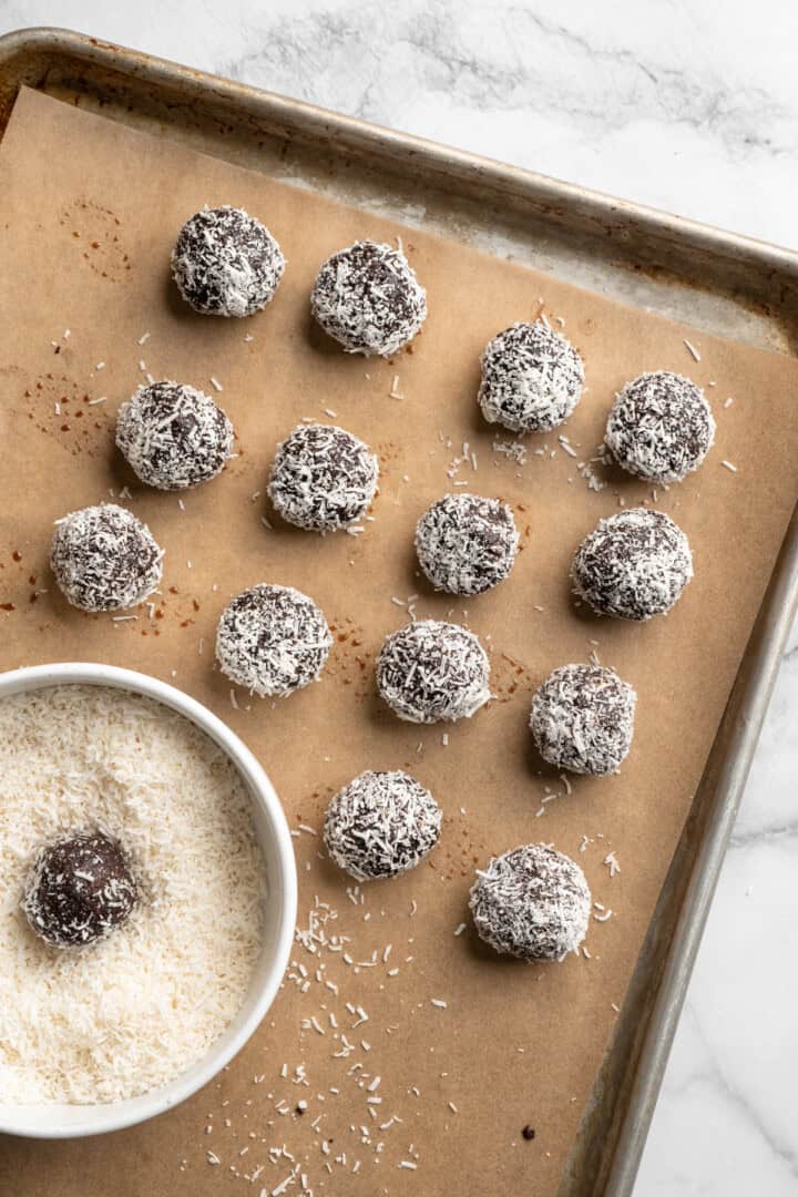 Pan with no bake brownie energy bites rolled in coconut.