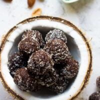 Brownie energy bites in a pile inside of a half of a dried coconut shell.