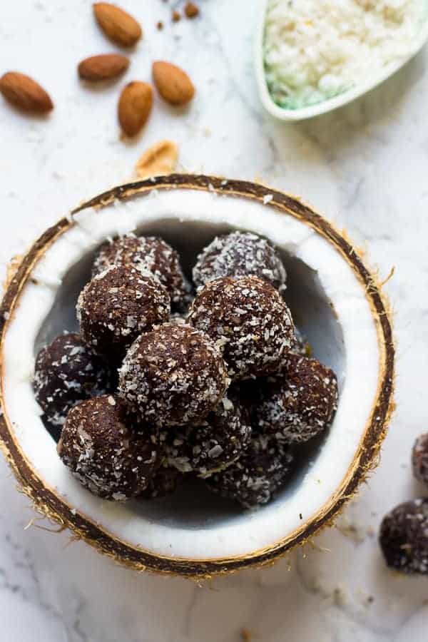 Overhead shot of no bake brownie energy bites in a coconut.