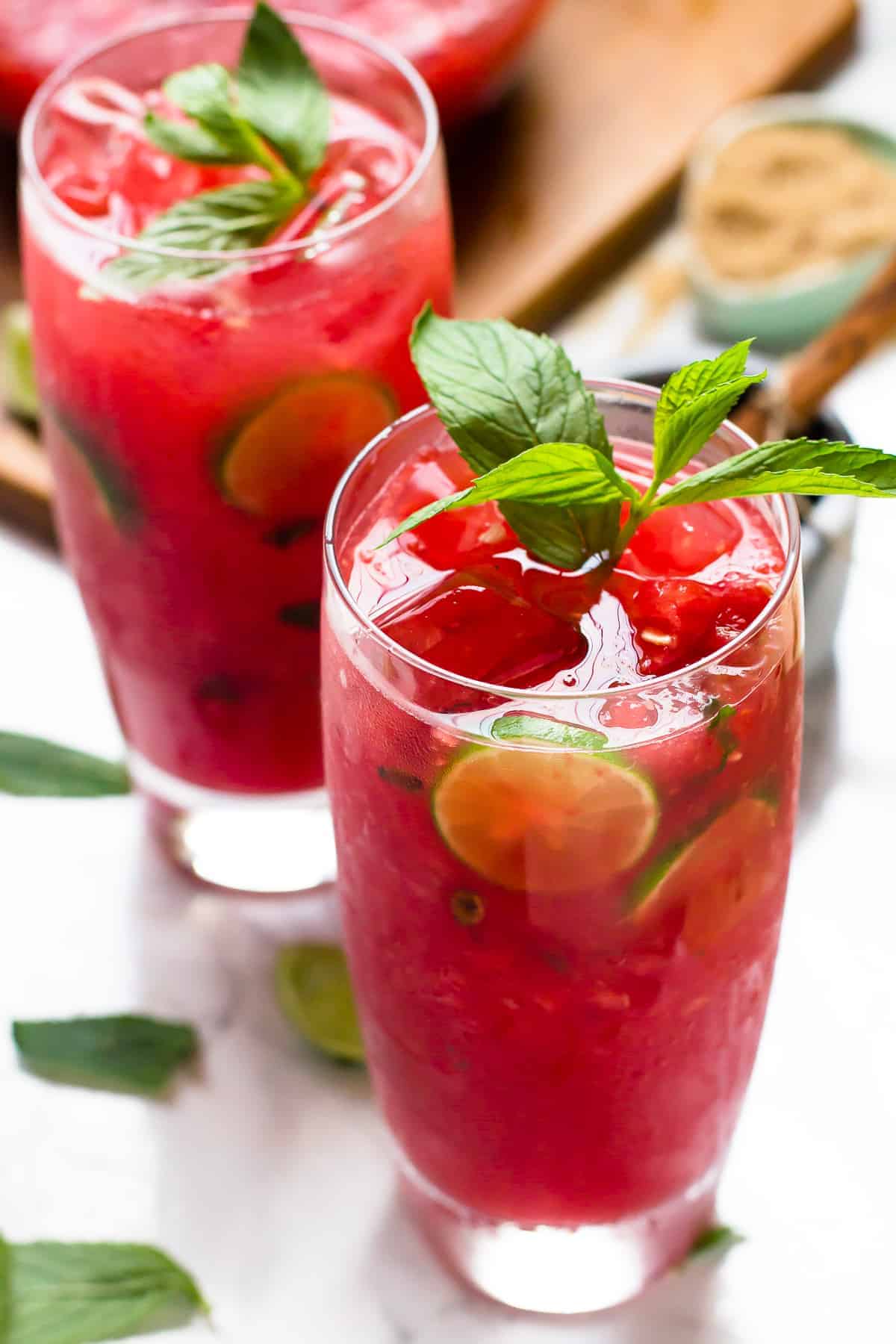 Two watermelon mojitos with fresh mint and limes