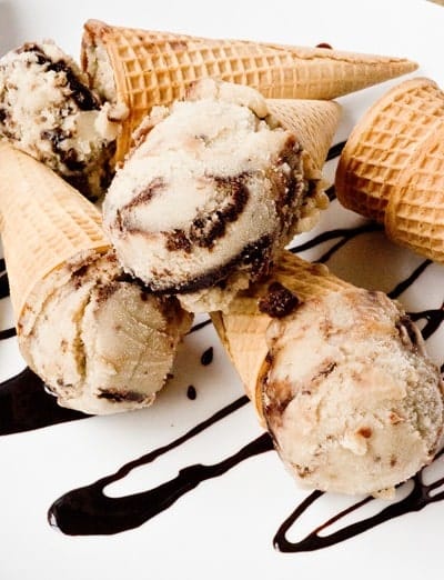 Chocolate chunk banana ice cream in cones drizzled with chocolate. 