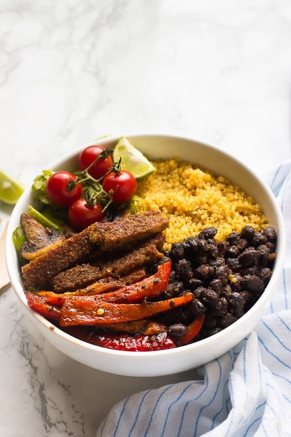 Vegan fajita bowl with a striped cloth on the side. 