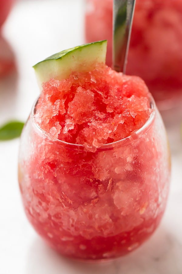 Close up of watermelon granita in a glass with a spoon in it. 