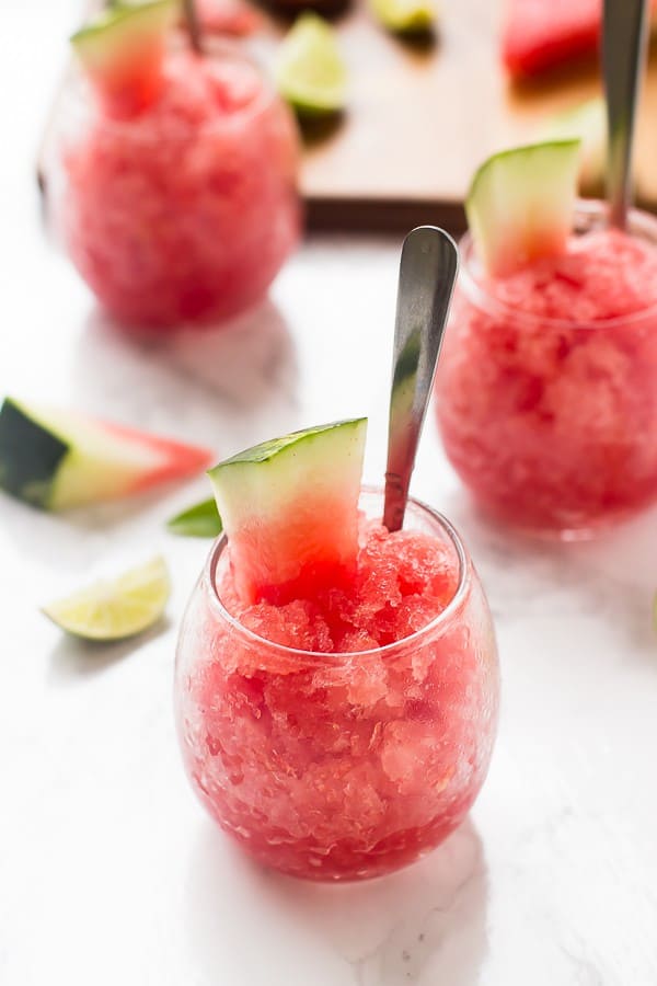 Watermelon granita in glasses with a silver spoon in them.