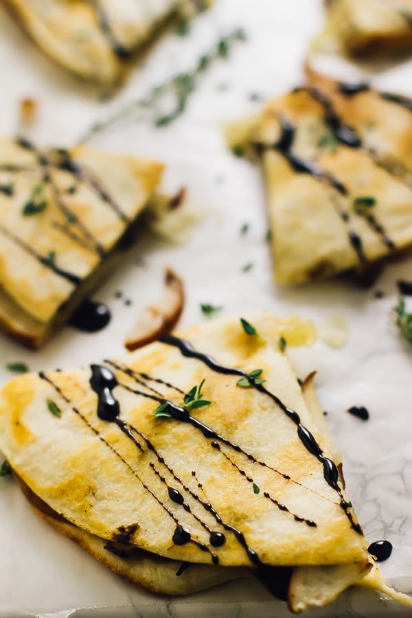 Close up of pear brie & caramelised onions quesadillas drizzled with a balsamic glaze.