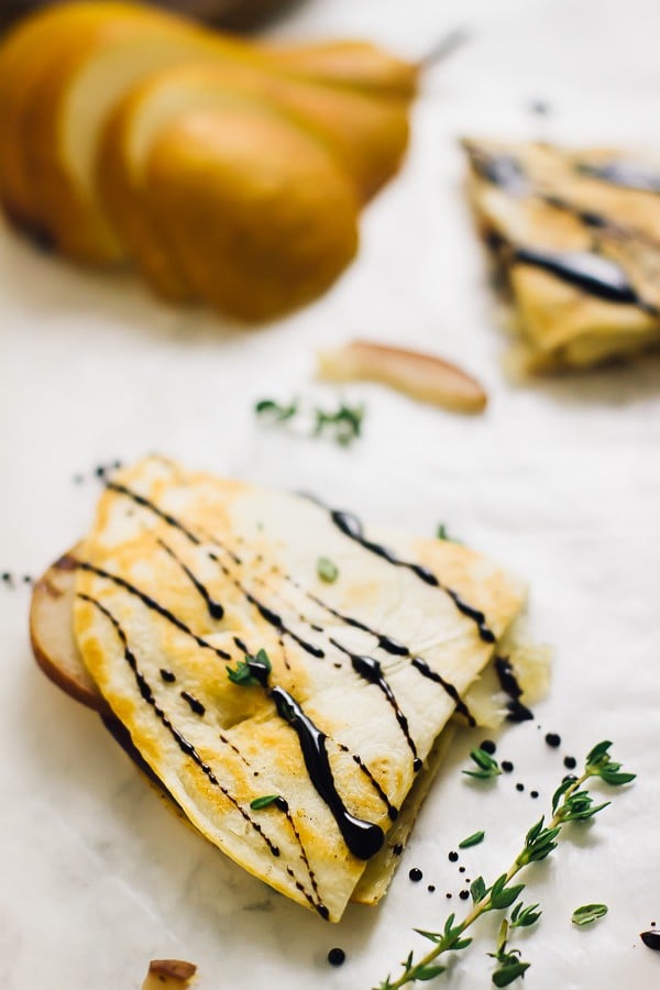 A slice of pear brie & caramelised onions quesadilla drizzled with a balsamic glaze.