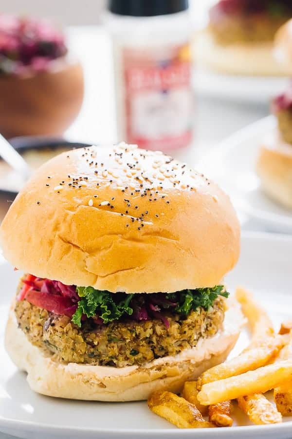 Side shot of a vegan quinoa cauliflower burger with fries on the side. 