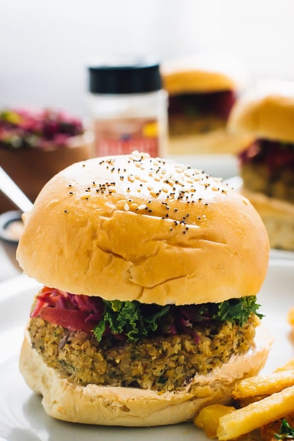 sidoskott av quinoa blomkålburger med pommes frites på sidan.