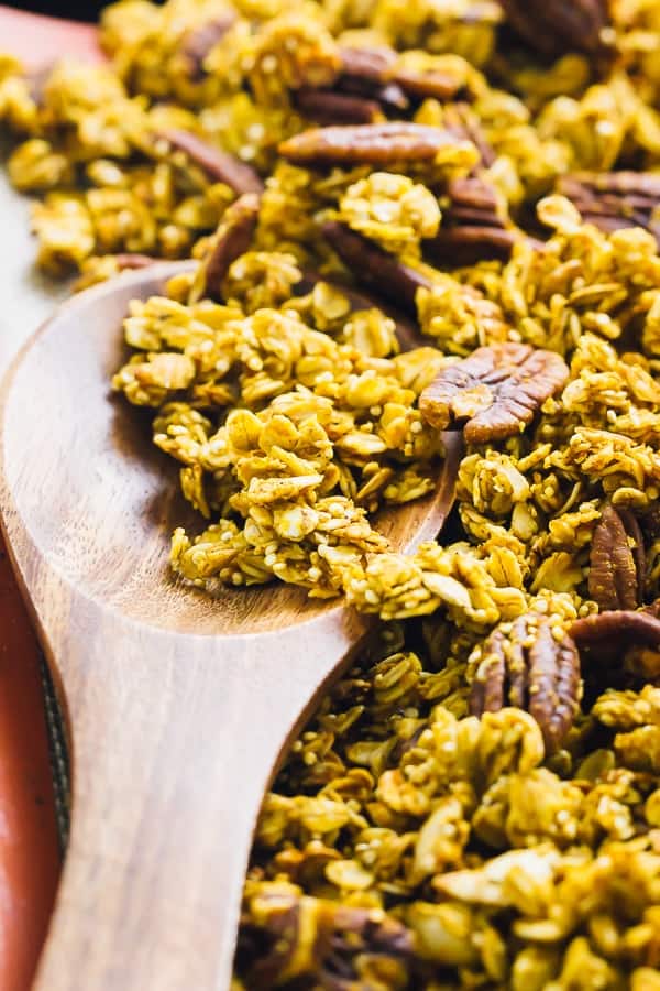 Close up of pumpkin spice granolas on a wooden spoon. 