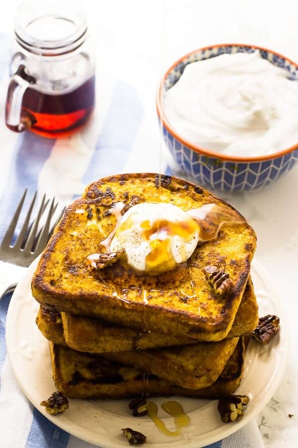 A stack of pumpkin french toast, drizzled with syrup. 