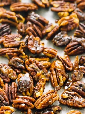 Top down shot of candied pecans on a baking tray.