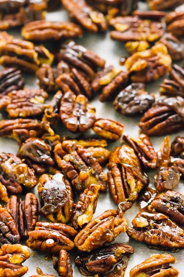 A close up of candied pecan on a baking sheet. 