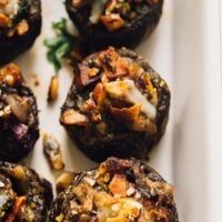 TOp down shot of coconut bacon stuffed mushrooms in a bacon dish.