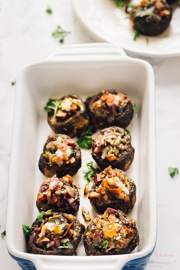 Overhead shot of stuffed mushrooms with coconut bacon in a long baking dish.