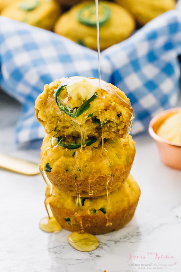 Syrup being drizzled on a stack of cornbread muffins.