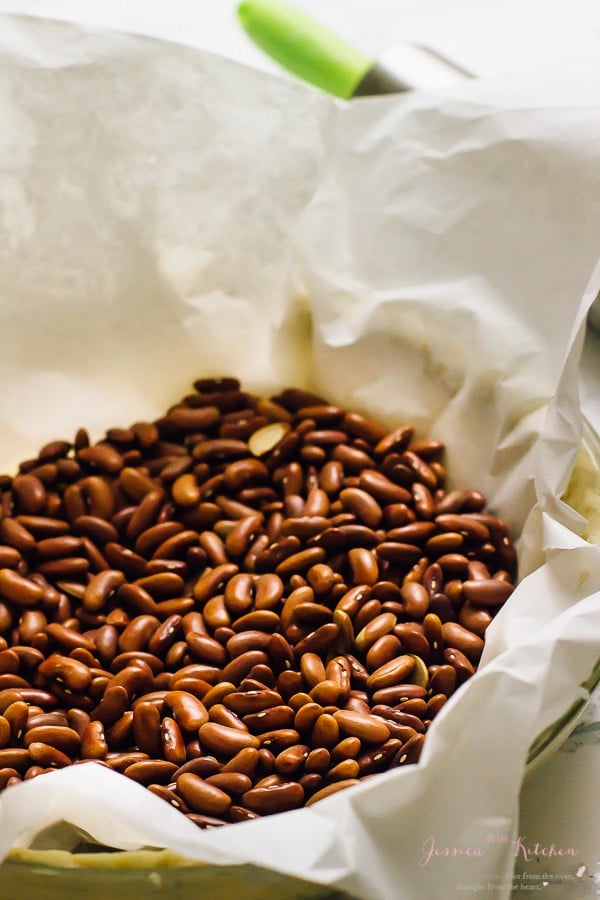 Beans in parchment-lined pie crust before baking