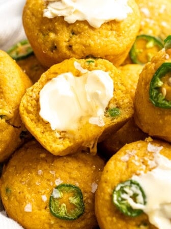 Vegan cornbread muffins topped with butter and flaky salt.