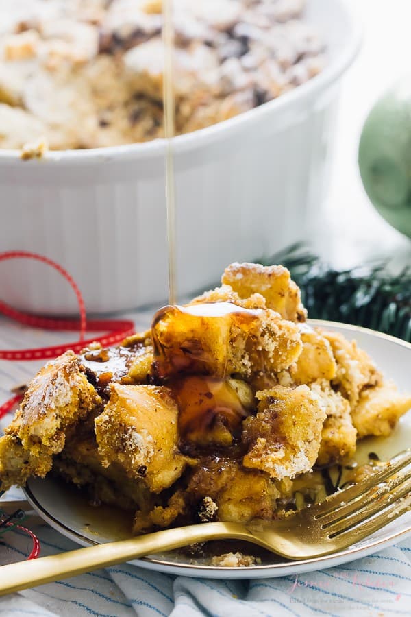 Drizzling syrup onto a portion of overnight french toast casserole.