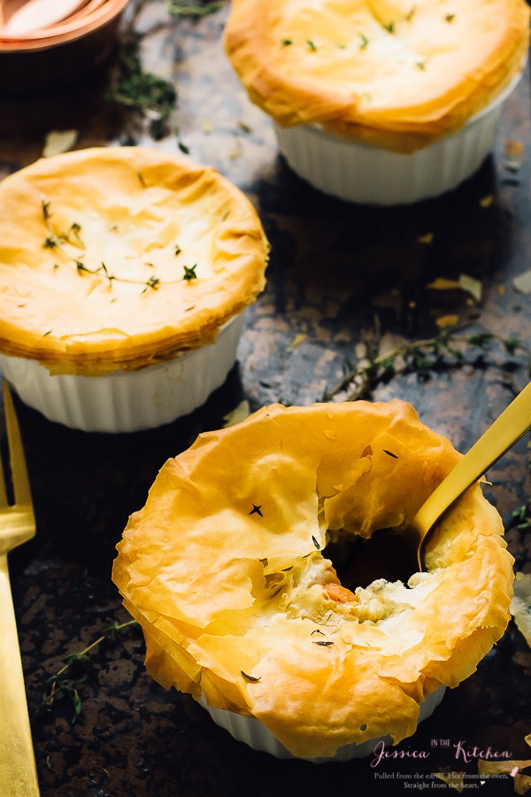 Vegan pot pies in white ramekins on a sheet pan. 