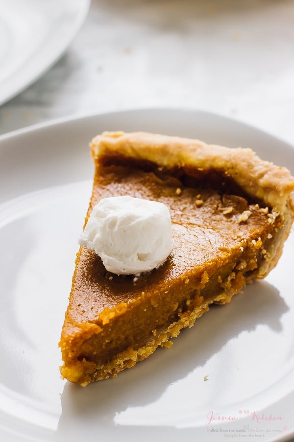 A slice of pumpkin pie with a scoop of cream on top. 