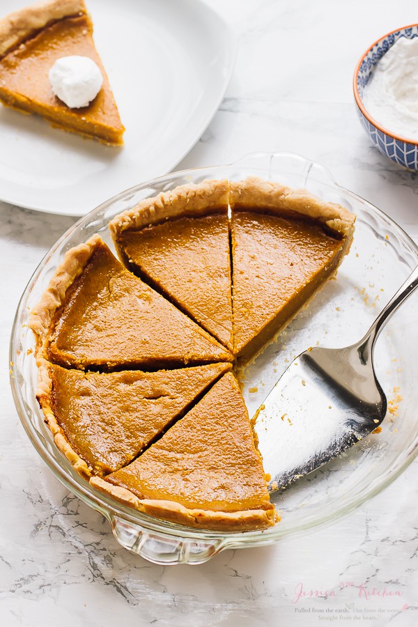 Sliced vegan pumpkin pie on a glass dish.