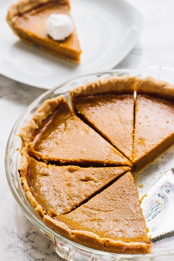 Sliced vegan pumpkin pie on a glass dish.