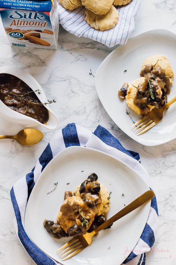 Top down shot of vegan mushroom gravy on top of biscuits with gold cutlery on the side. 