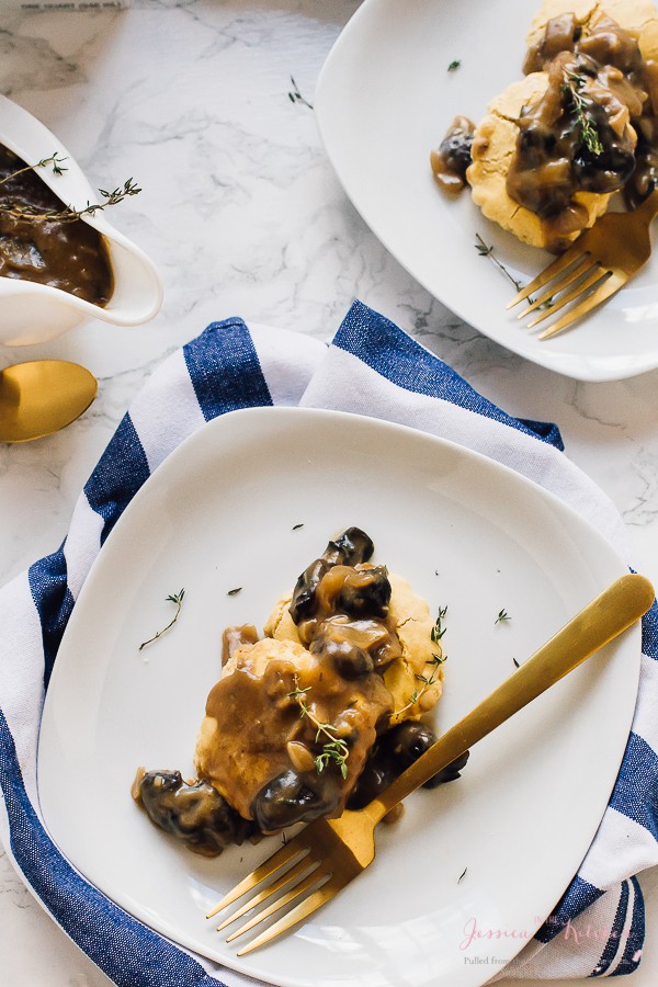 Overhead shot of vegan mushroom gravy on top of biscuits with a gold fork on the side. 