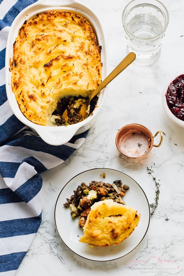 Top down view of vegan shepherd's pie in a baking dish and on a plate. 