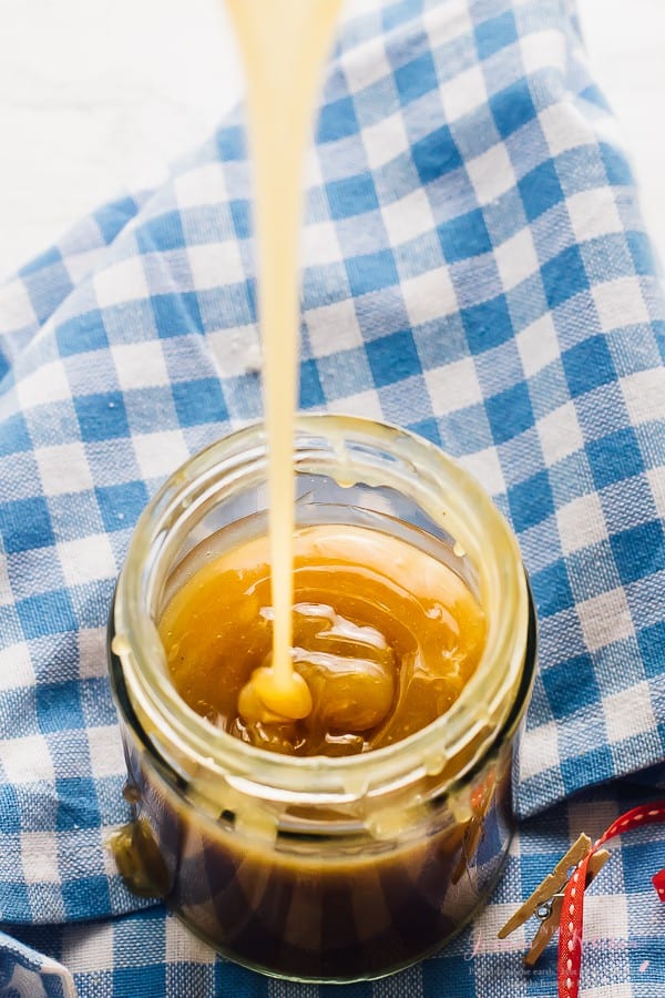 Vegan caramel sauce being poured into a glass jar. 