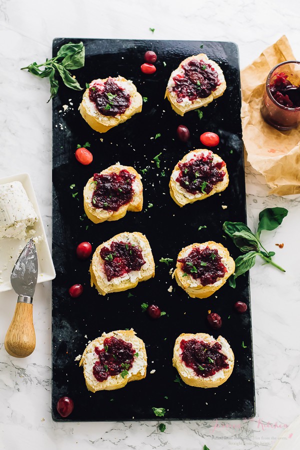 Overhead shot of goat cheese crostini on a black slate. 