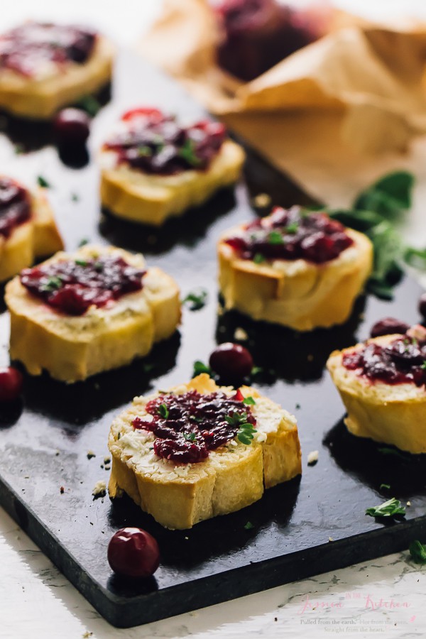 Close up of goat cheese crostini on a black slate. 