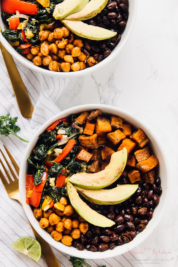 Top down shot of two salad bowls with golden cutlery on the side. 