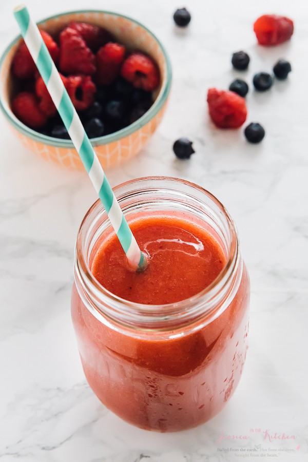 Top down shot of banana berry smoothie in a mason jar with a straw.