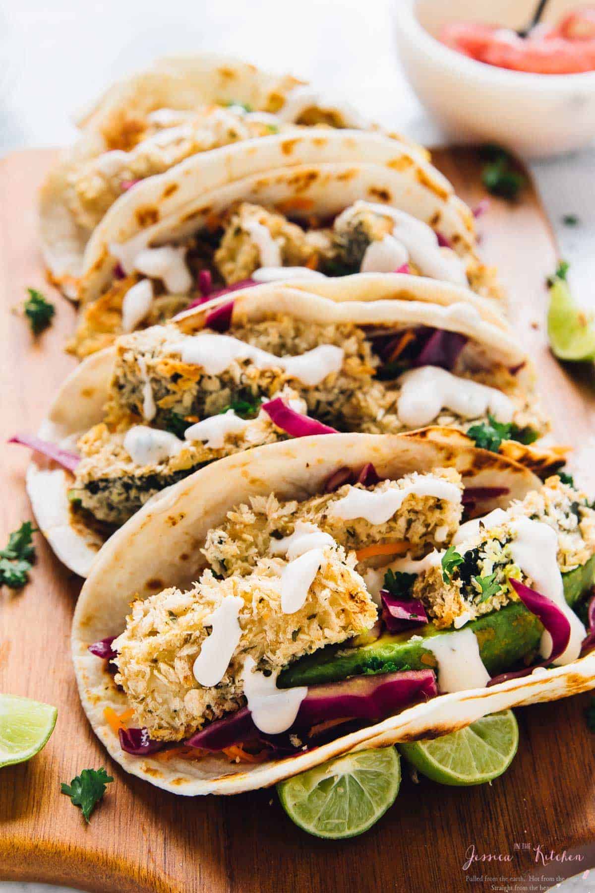 4 crispy zucchini tacos lined up on a cutting board