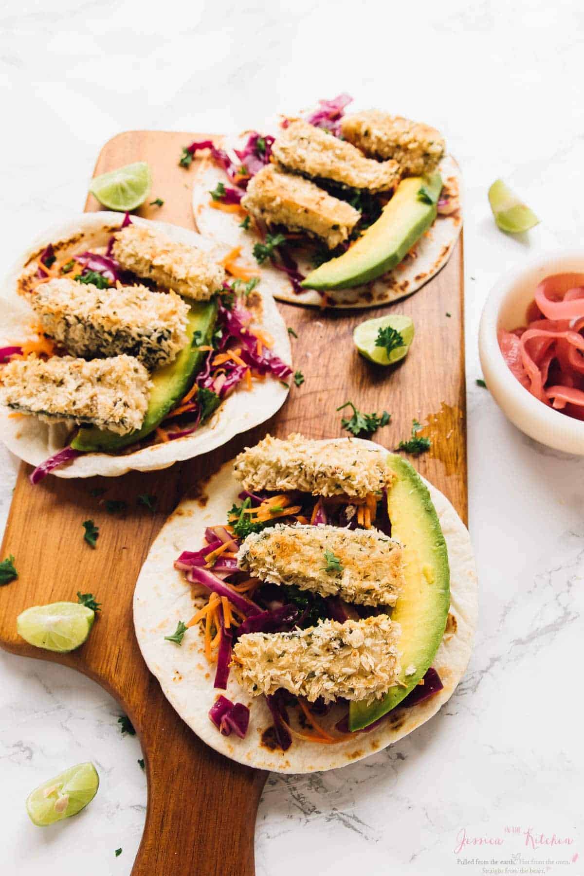 Three crispy zucchini tacos on a wood board