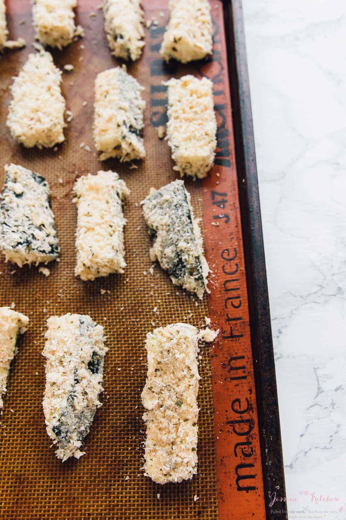 Crispy zucchini pieces on silpat-lined baking sheet