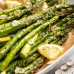 Garlic roasted asparagus with lemon wedges in serving bowl. - 8