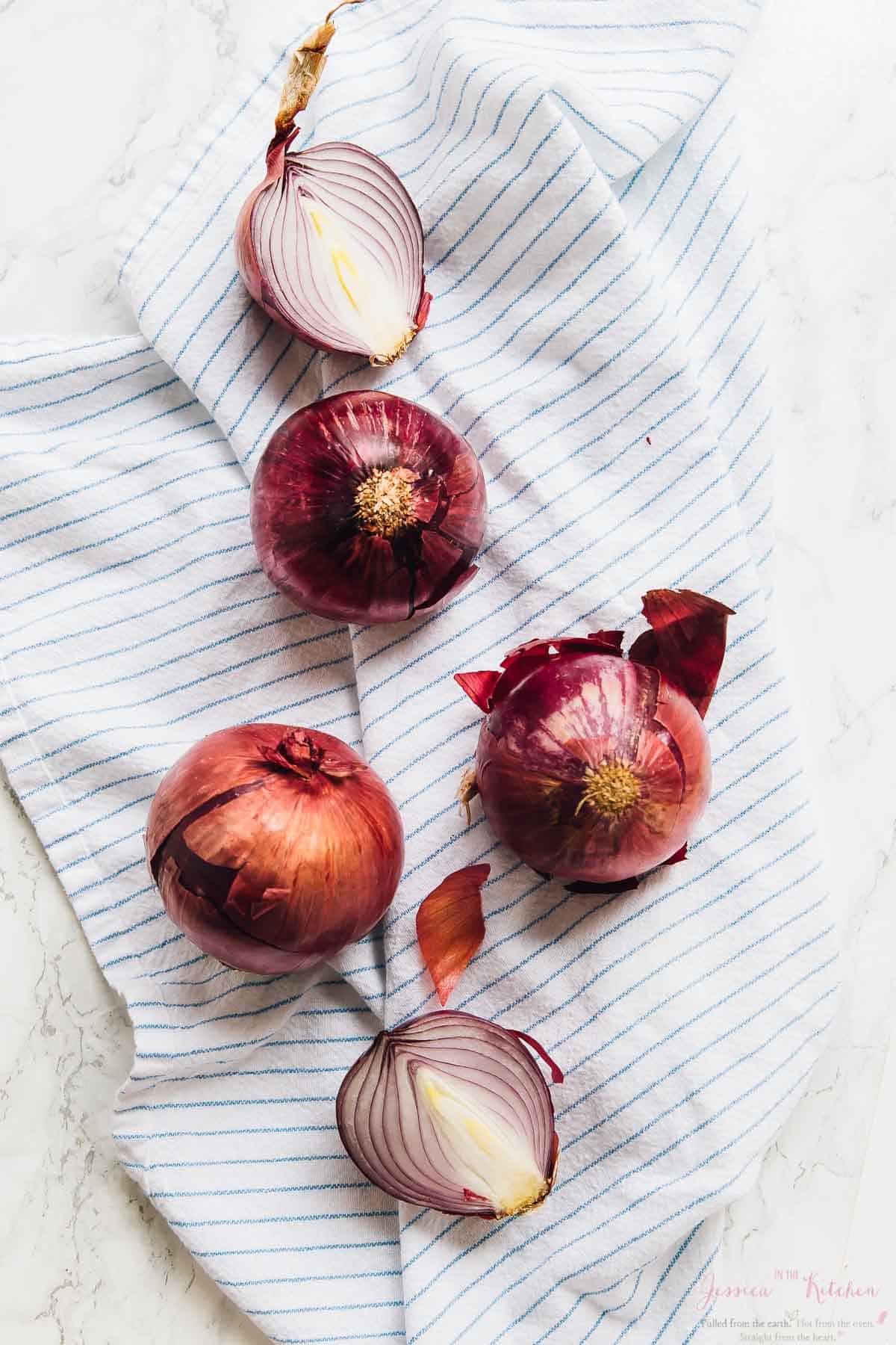 Raw onions on a striped cloth. 