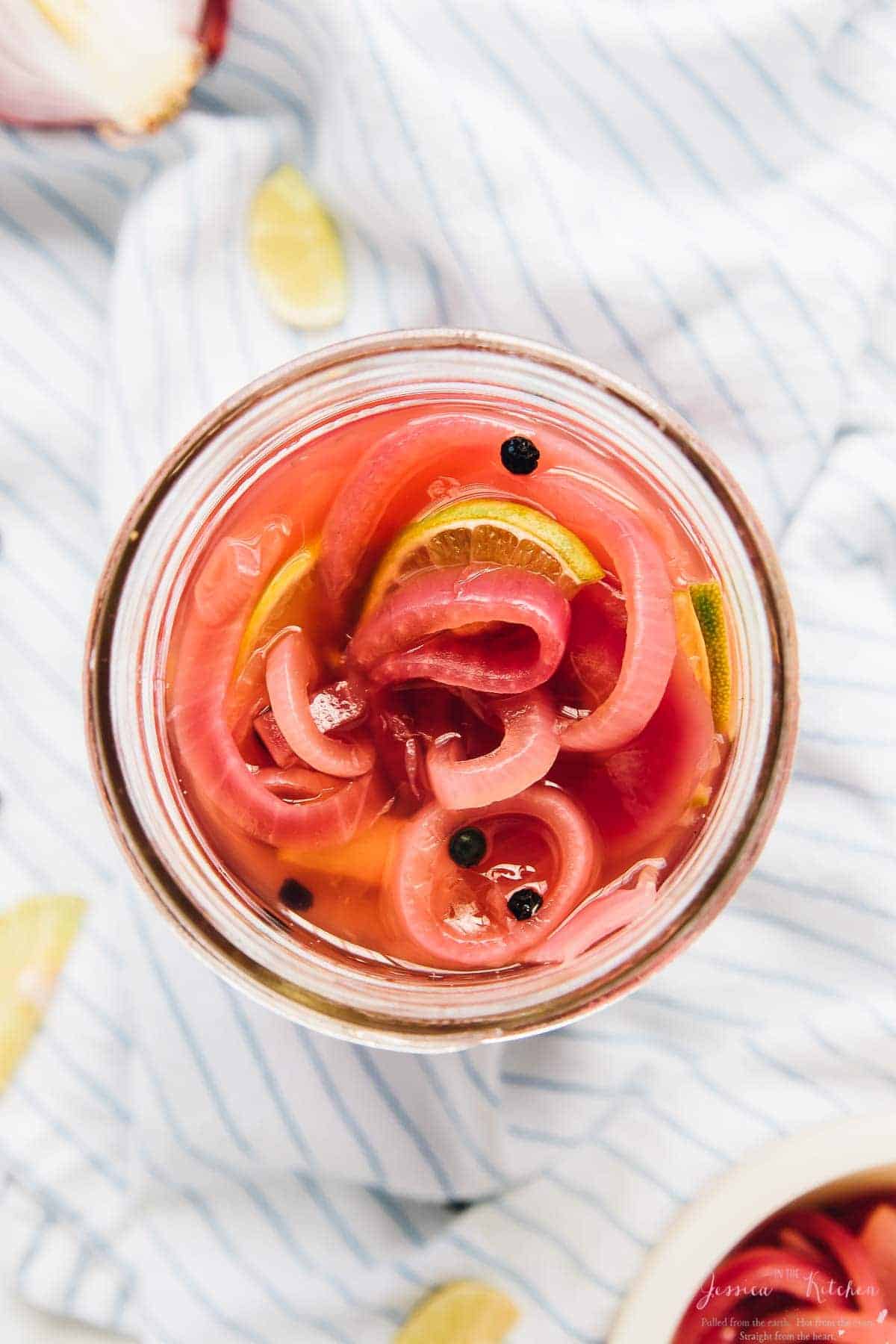 Overhead shot of quick pickled onions in a glass jar. 