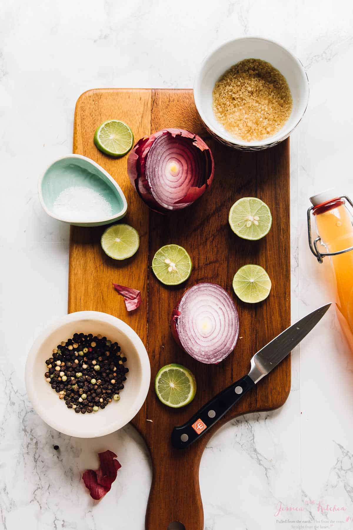 Top down shot of ingredients for quick pickled onions on a wooden board. 