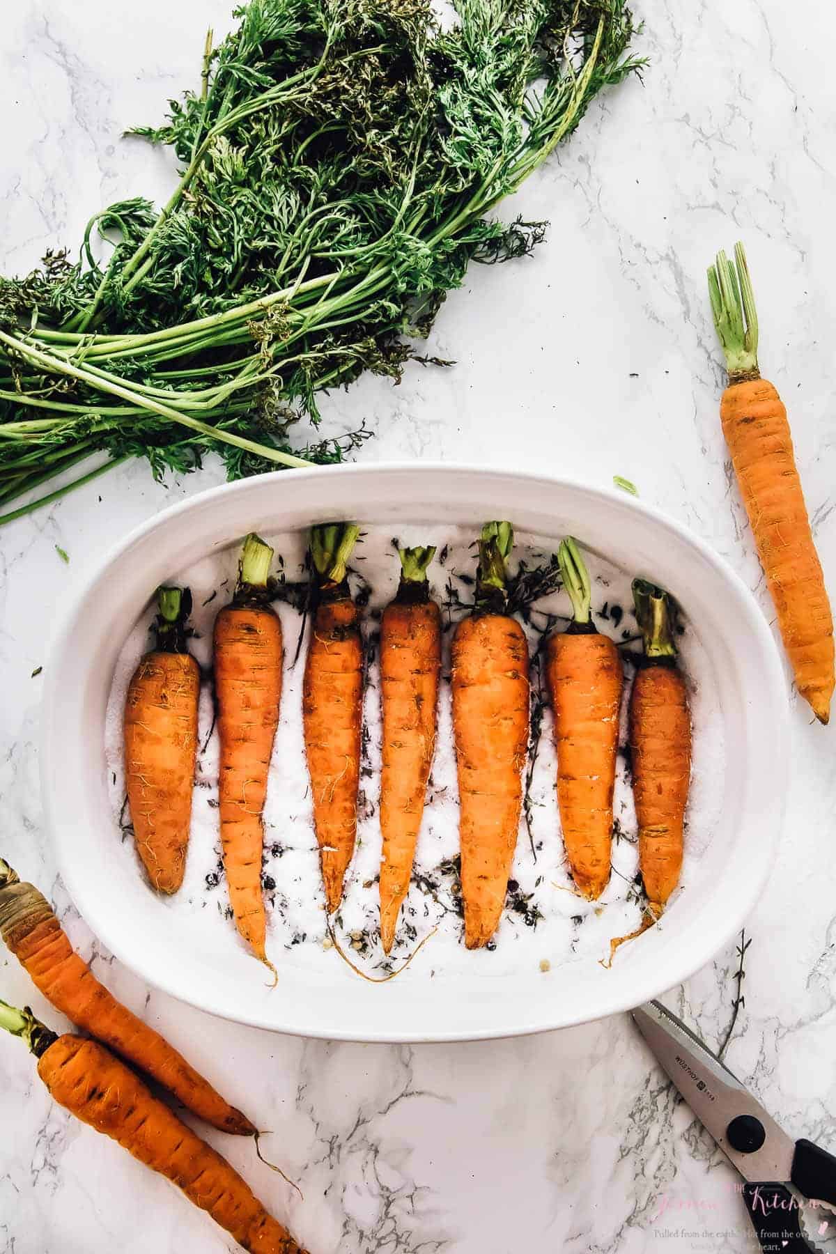 Overhead shot of carrots in a baking dish on a bed of salt. 