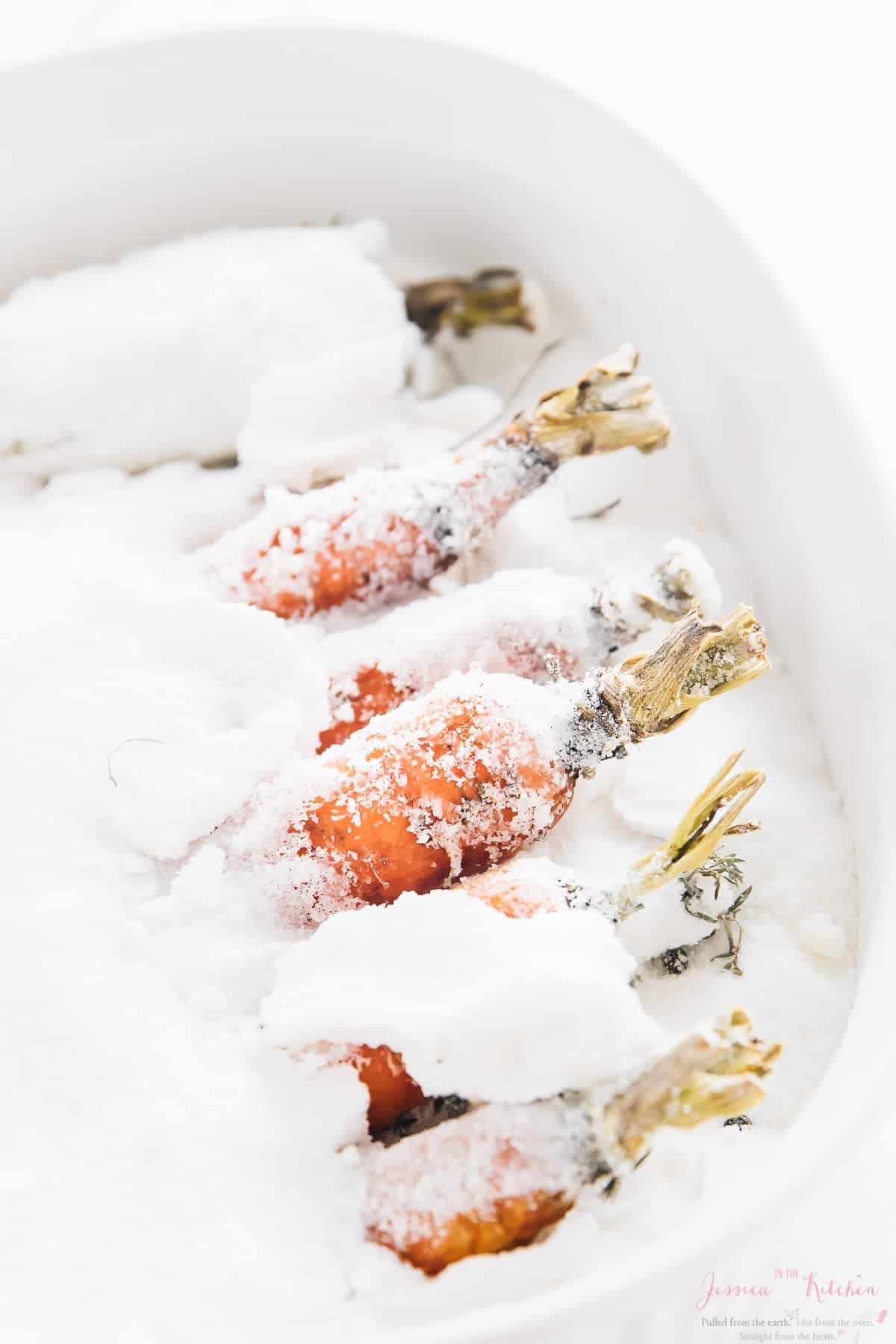 A close up of carrots covered in salt. 